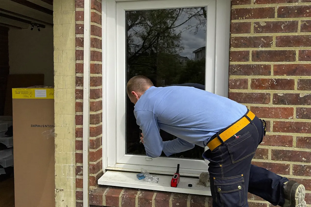 Installer fitting a new uPVC double glazed window in a home